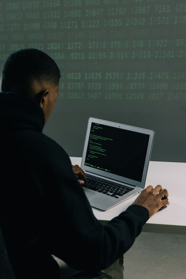 A man sitting at a table with a laptop.